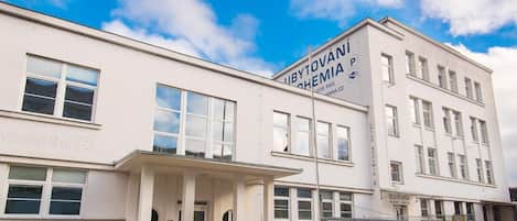 A white building with multiple windows and a sign that reads 'UBYTOVANI BOHEMIA'.