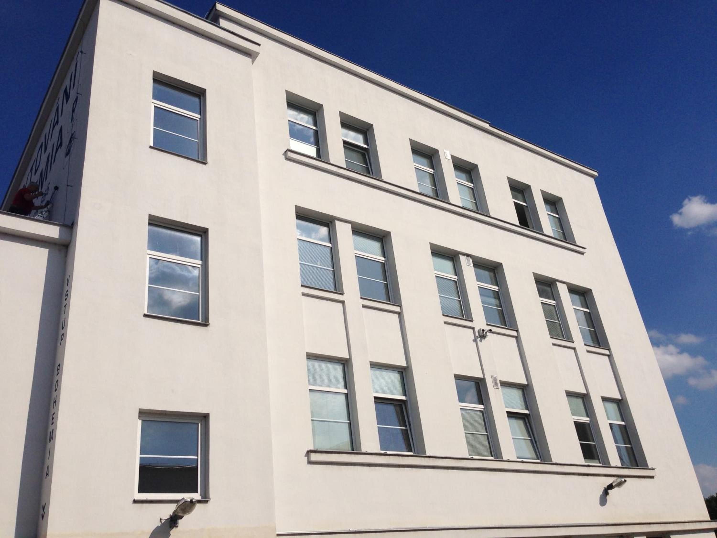 A multi-story building with a flat facade and rectangular windows.