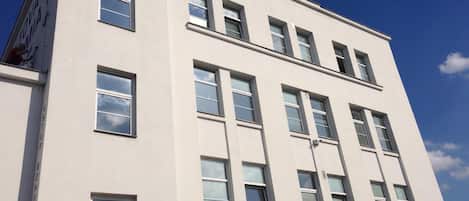 A multi-story building with a flat facade and rectangular windows.