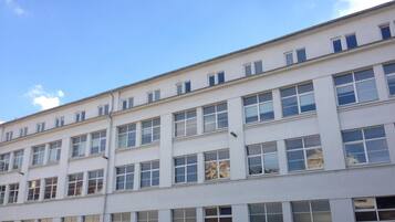 Un edificio de varios pisos con fachada plana, ventanas amplias y cielo despejado.