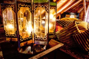Quarto com lanternas decorativas e almofadas tradicionais.