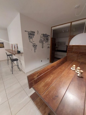 Un comedor con una mesa de madera, sillas y una pared con un diseño de mapa mundial.