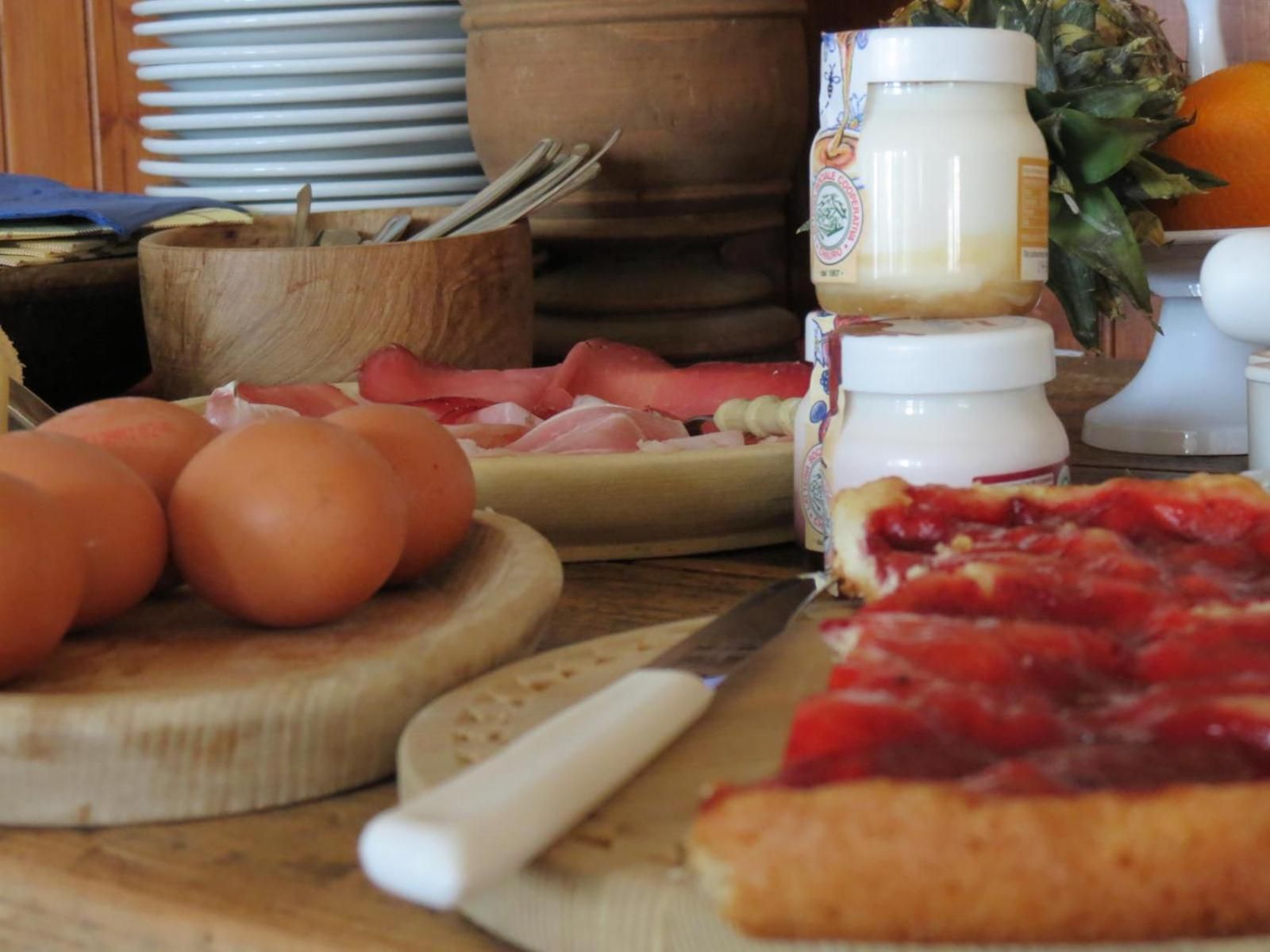 Un plan de travail de cuisine avec une planche à découper, un couteau, un pot de confiture et une part de pizza.