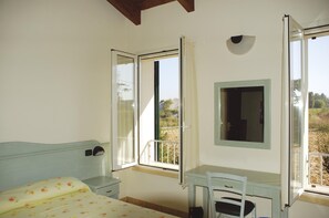 A bedroom with a bed, a desk, and a window with curtains. - Albergo Del Po (Parma)