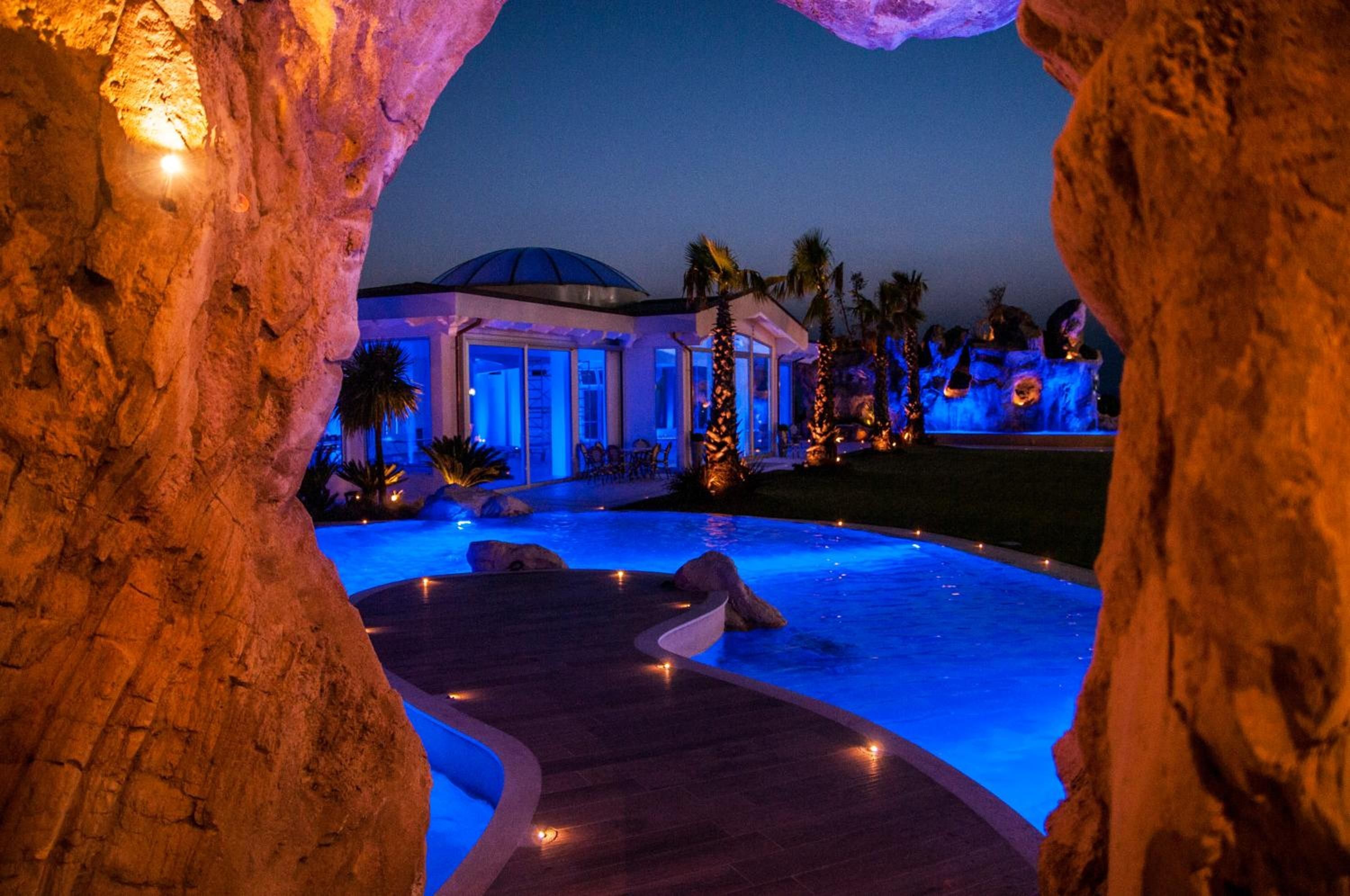 Ein Resort mit Swimmingpool, überdachtem Bereich und Palmen.