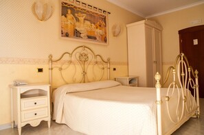 Quarto com cama, mesas de cabeceira, guarda-roupa e um quadro na parede.