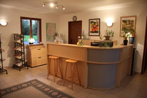 Una cocina con una isla central, taburetes de bar, una estantería y un mapa en la pared.
