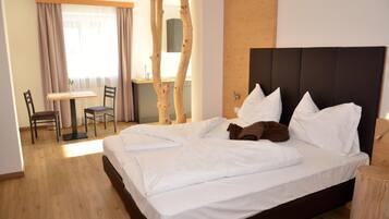A hotel room with a bed, a desk, and a chair.