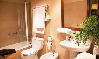 Un baño con ducha, inodoro, bidé y lavabo.