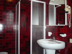 A bathroom with a white sink, a mirror, and red-tiled walls. - Hotel Ristorante Dotto (Maserada sul Piave)
