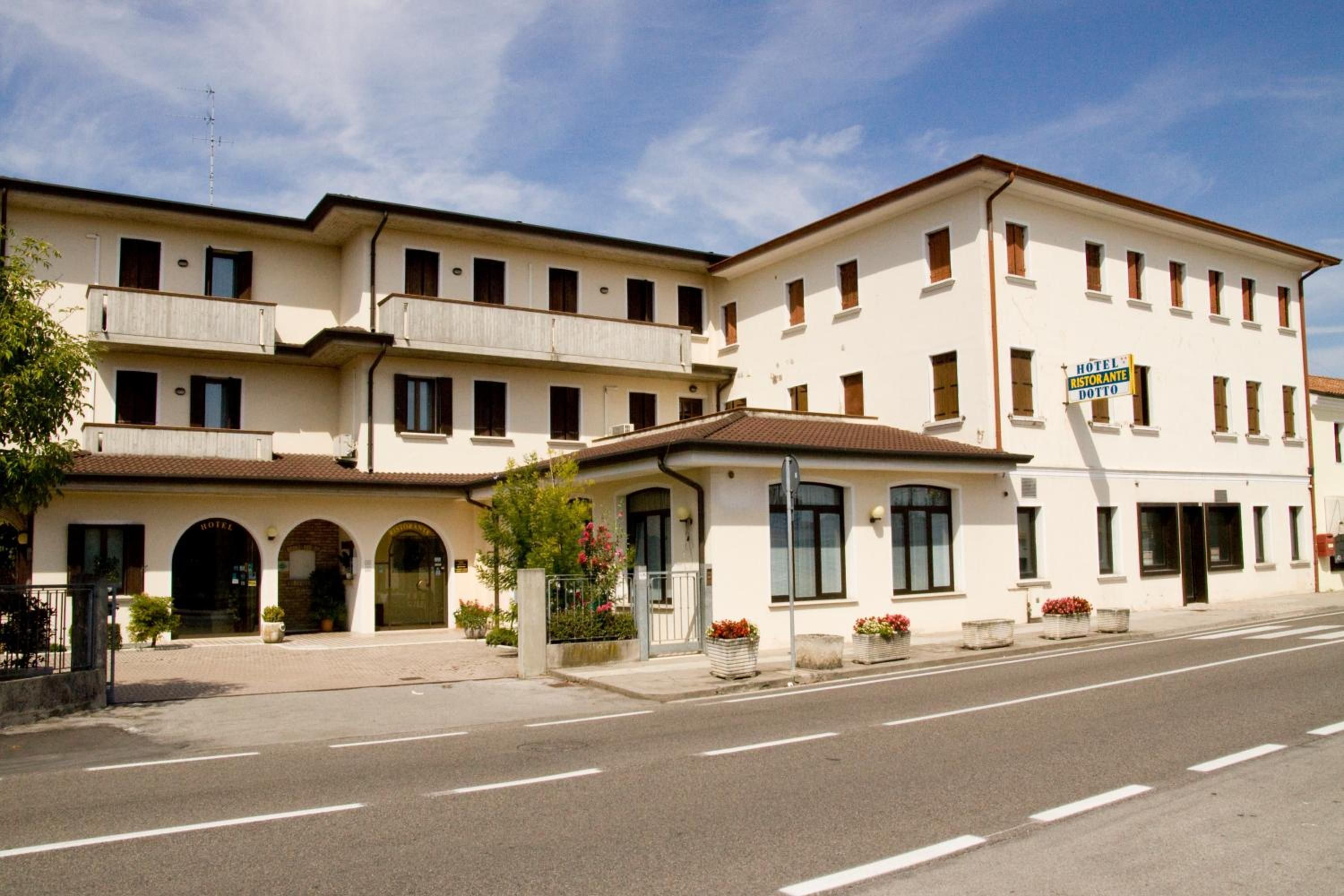 A hotel with multiple floors, a restaurant, and a dotto sign.