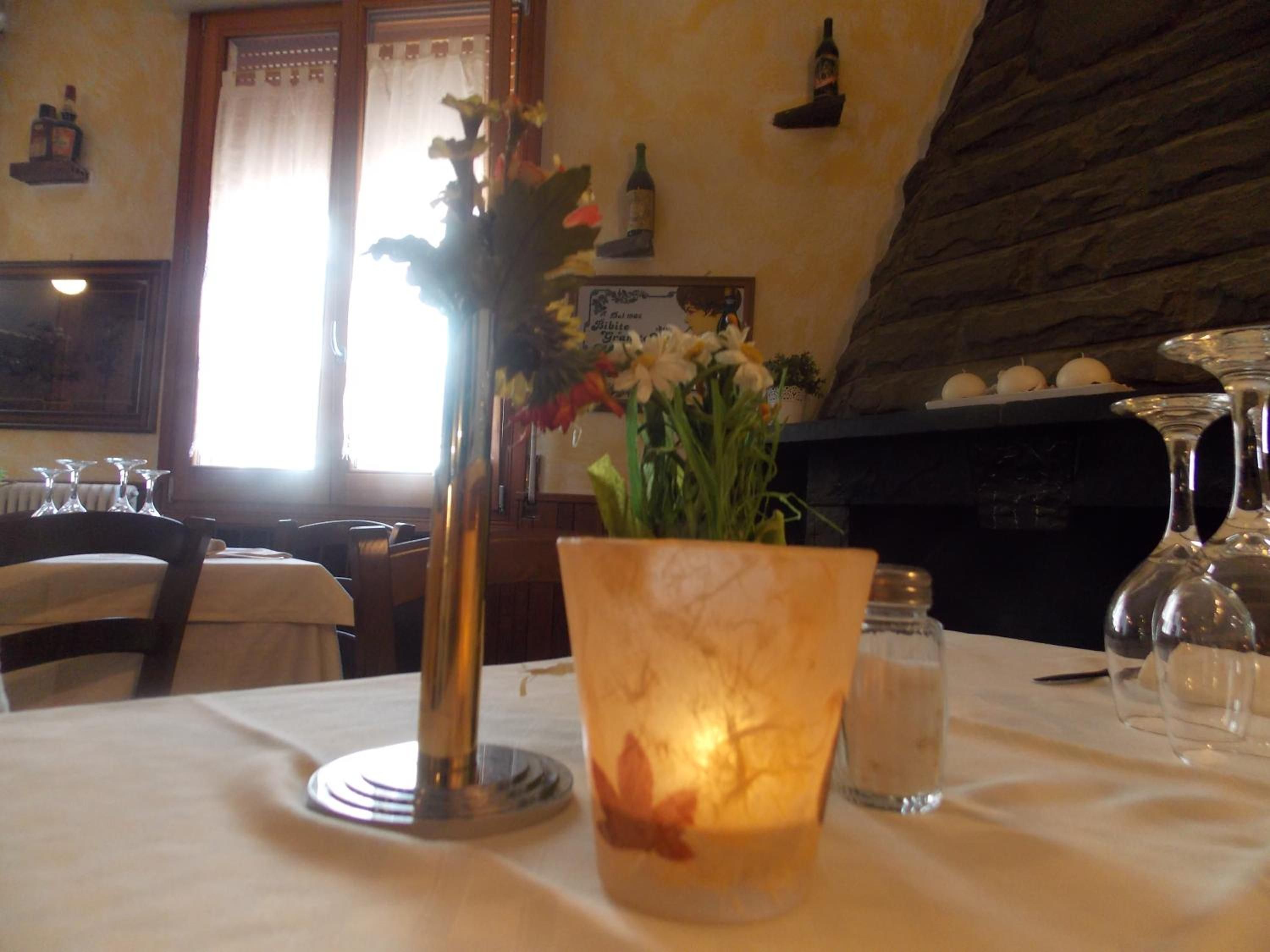 A dining table with a candle holder and a vase with flowers.