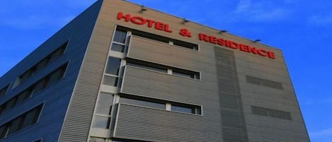 A hotel building with a sign reading 'HOTEL & RESIDENCE' on the facade.