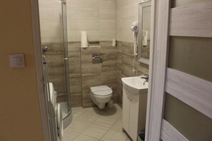 Une salle de bain avec une douche à parois de verre, des toilettes et un lavabo.