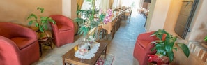 A dining area with red chairs, a long table, and potted plants. - Hotel Palazzon Gradenigo (Riese Pio X)