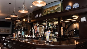 Un bar con varias griferías de cerveza, una máquina de Pepsi y un arpa.