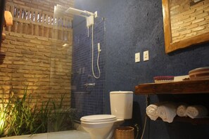 A bathroom with a shower, toilet, and a shelf with towels. - Zazen Pousada By Santoregano (Maceió)
