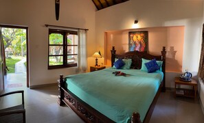 A bedroom with a bed, a nightstand, a window, and a painting on the wall.