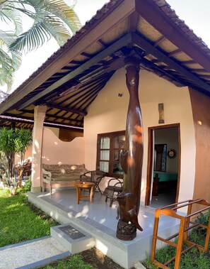 A house with a porch, a wooden bench, a table, and a chair. - 1000 Dream Bungalow (Buleleng)