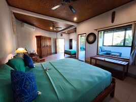 Un dormitorio con cama, escritorio, silla, ventana y vistas al exterior.
