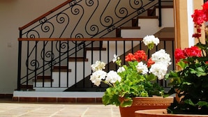 A two-story building with a staircase featuring ornate metal railings and decorative wall plates.
