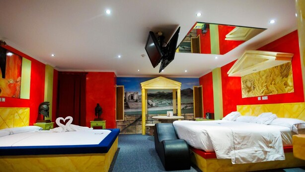 A hotel room with two beds, a TV, a mural, and a small table. - Motel Venus Valladolid (Villanubla)