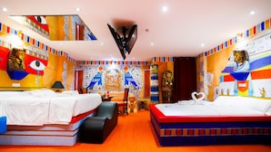 A hotel room with two beds, a large mirror, and walls decorated with Egyptian-themed artwork. - Motel Venus Valladolid (Villanubla)