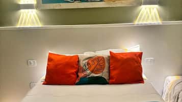 Quarto de hotel com cama, almofadas, um quadro e toalha.