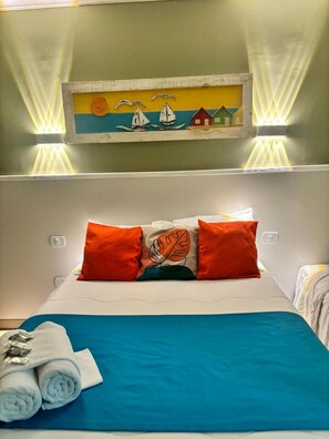 Habitació d'hotel amb un llit, almoines, un quadre i una tovallola.