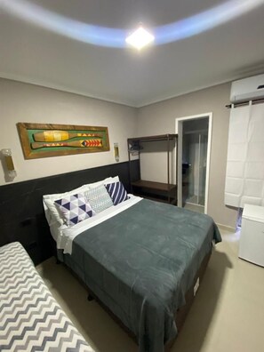 Un dormitorio con cama, armario, espejo y puerta.