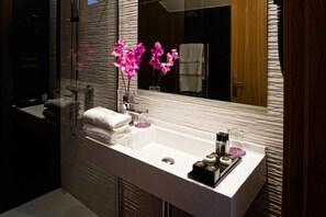 A modern bathroom with a large mirror, a white sink, and a towel rack. - Saiaritz (Amurrio)