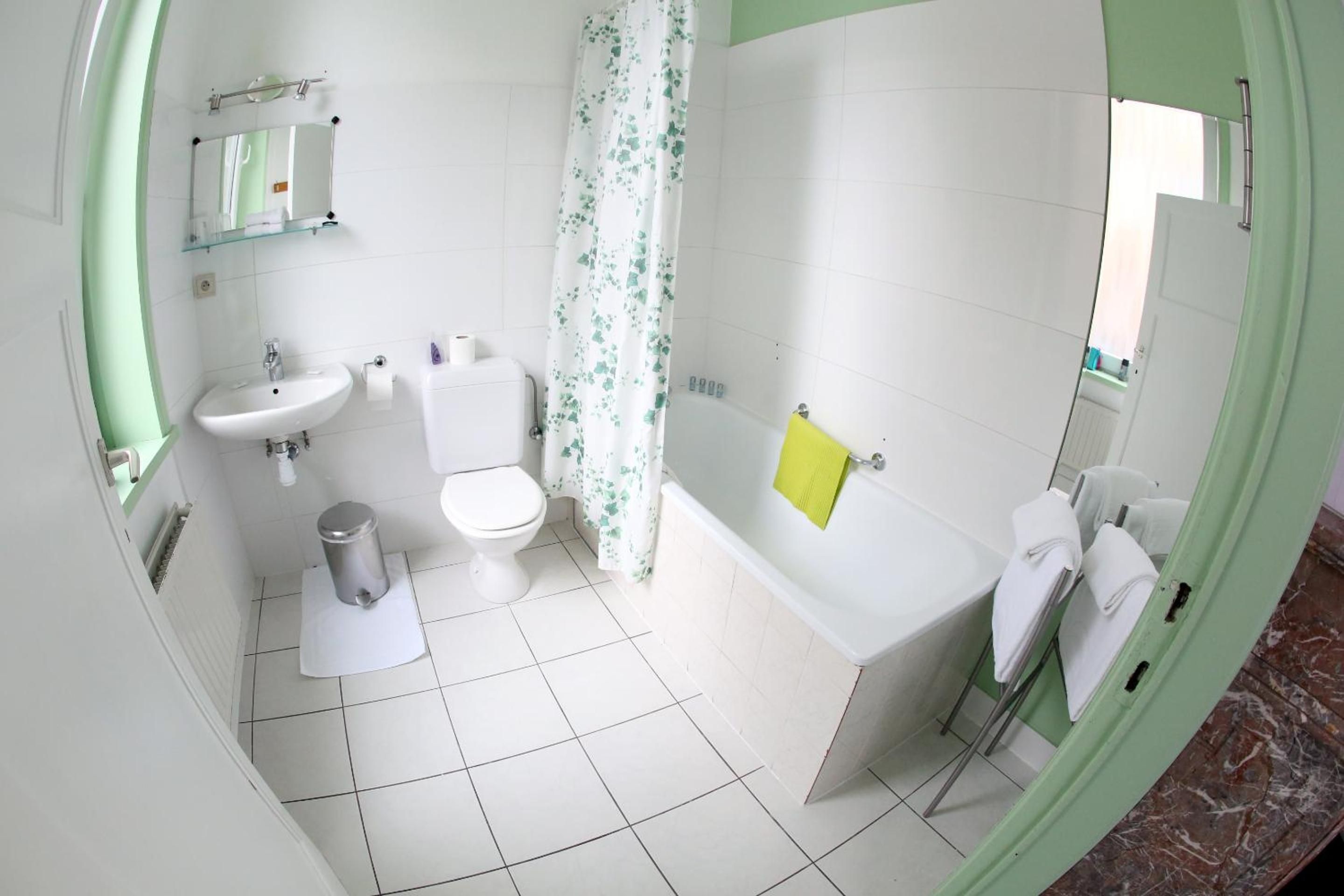 Een badkamer met een wastafel, toilet, bad en douchegordijn.