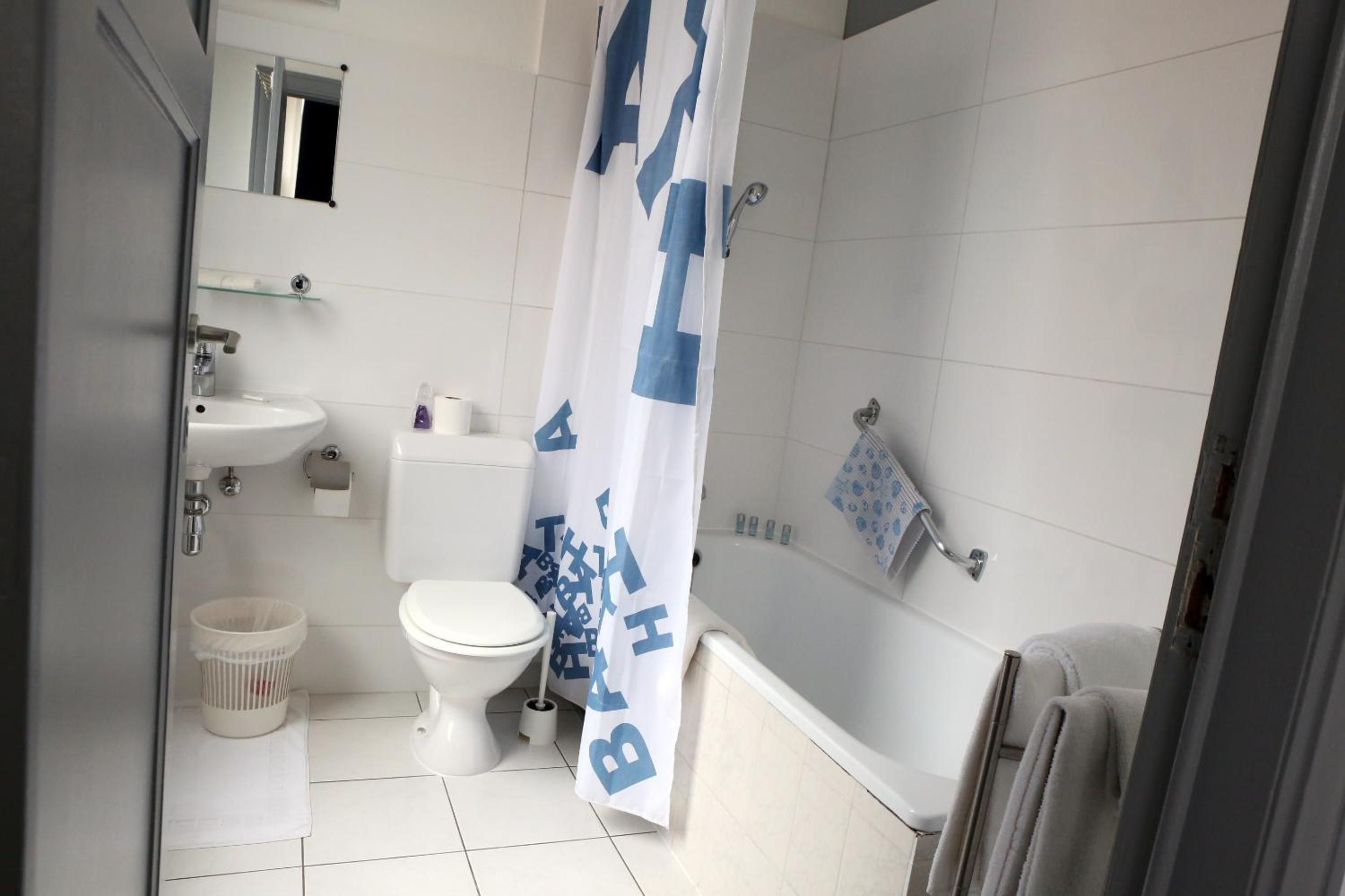 Une salle de bain comprenant des toilettes, un lavabo et un espace douche.