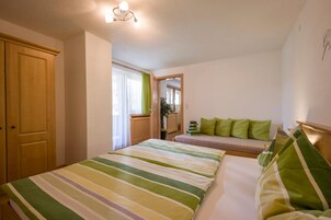 Un dormitorio con cama, sofá, armario y espejo.