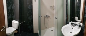 A bathroom with a toilet, a shower, and a sink. - Boulevard Sea Residence (Nessebar)