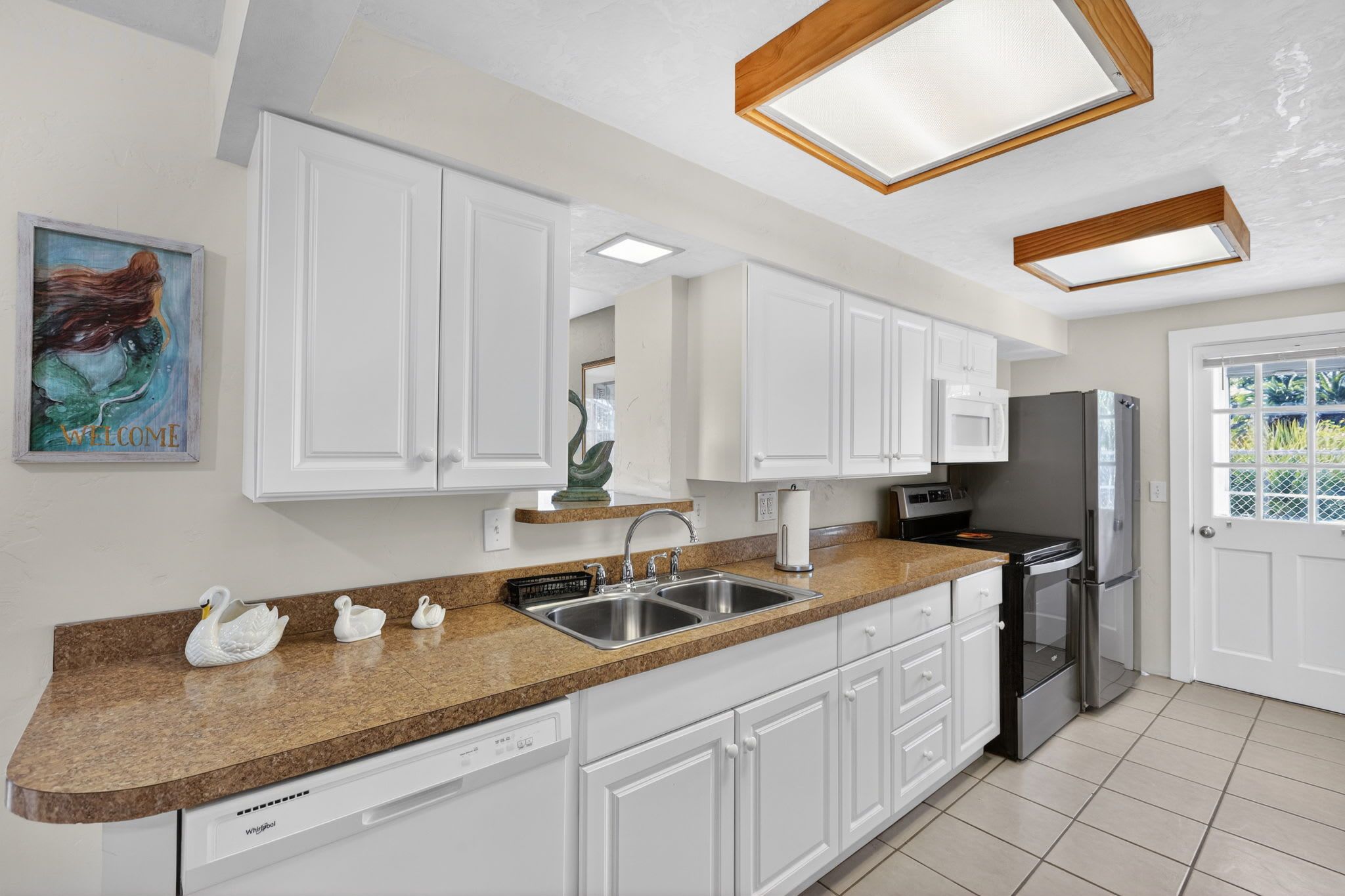 A modern kitchen with white cabinets, stainless steel appliances, and a granite countertop.