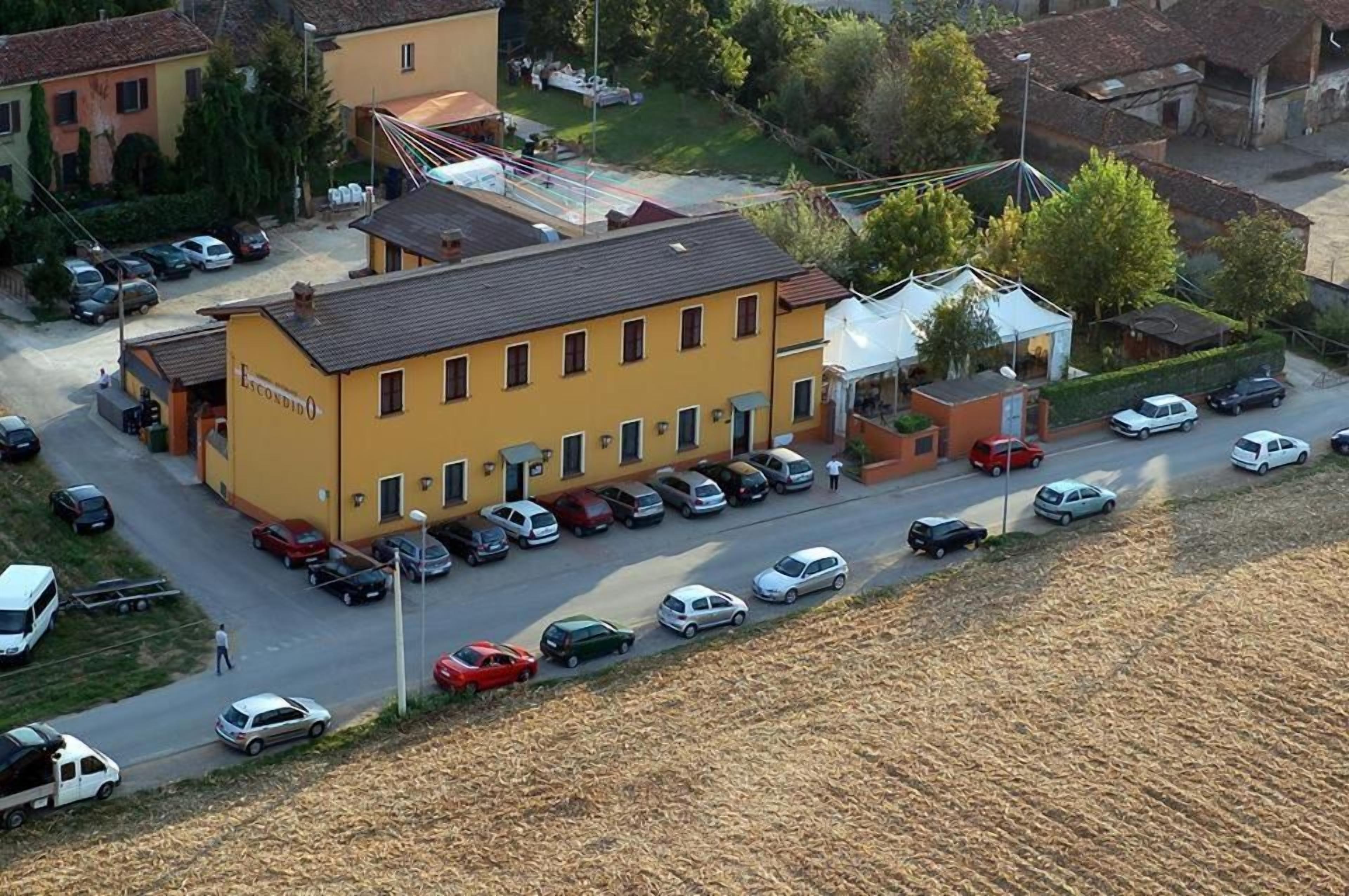 A yellow building with a parking lot and a field in the foreground.