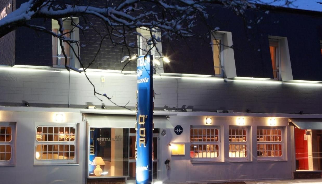 A building with a restaurant sign, a blue pole with text, and multiple windows.