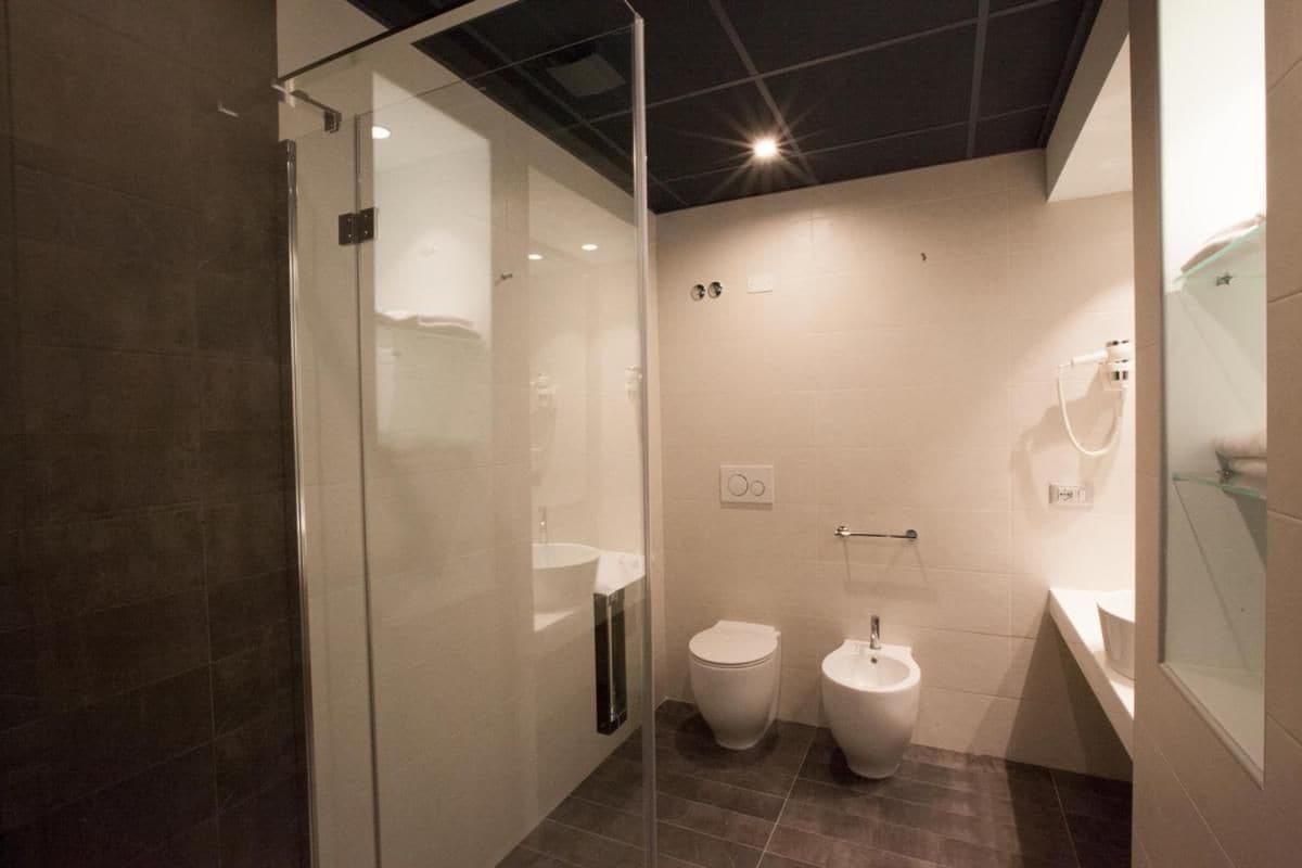 Un baño moderno con cabina de ducha de vidrio, inodoro y bidé.