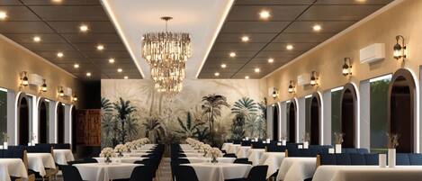 A long dining room with tables and chairs, a chandelier, and wall-mounted lights.