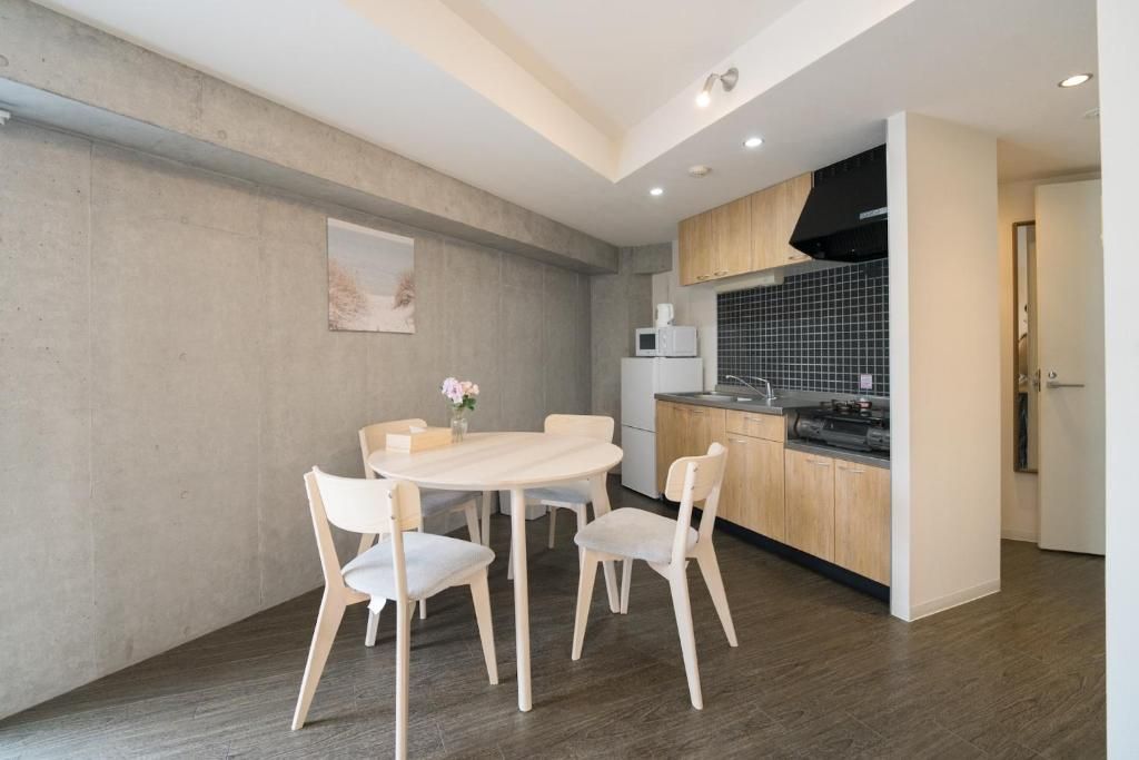 A modern kitchen with a dining area, featuring a round table, four chairs, and a microwave.