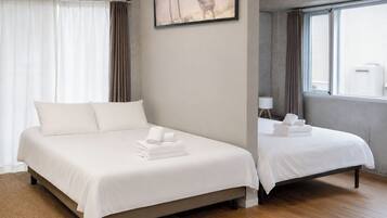 A hotel room with a large bed, a smaller bed, and a painting of a deer on the wall.