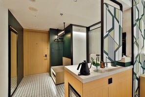 Un baño moderno con lavamanos, espejo y toallero.