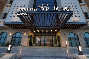Das Hotel Vivian Park mit modernem Design, inklusive einer markanten Eingangspforte und einer Beschilderung in Englisch und Arabisch.