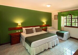 A room with a large bed, a smaller bed, two nightstands, and a window with curtains. - Hotel Y Cabañas Del Leñador (Puerto Iguazú)