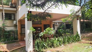 A courtyard with a covered seating area, surrounded by plants and trees. - Hotel Y Cabañas Del Leñador (Puerto Iguazú)