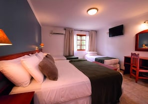 A hotel room with two beds, a desk, a chair, a TV, and a window with curtains. - Hotel Y Cabañas Del Leñador (Puerto Iguazú)