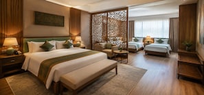 Quarto de hotel com uma cama grande, duas camas menores, um sofá, uma escrivaninha e um painel decorativo.