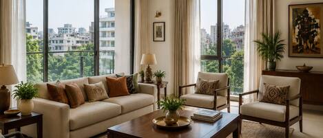 A modern living room with a sofa, two armchairs, a coffee table, and a view of the city through large windows.