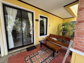 A bench outside a yellow building with a sliding glass door and a window. - Puerto Del Sol Beach Resort And Hotel Club (Bolinao)